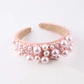 Primer plano de diadema de perlas rosas tejidas con forro interior de ante beige suave - Rosa