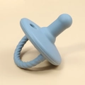 Detail of blue silicone baby pacifier with textured twisted handle on beige background - Grey Blue