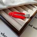 Détail d'une pince à cheveux rouge avec strass dans un coffret à bijoux en bois - Rouge Rose Cœur
