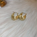 Close-up of golden irregular hoop earrings with matte metal texture on soft white fur - 27# Ear Buckle - Huggie Brushed Style