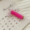 Detailed shot of pink spiral hair tie with purple resin bow and gold clasp - Bow Telephone Line Ring / Lavender