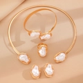 Vista detallada del conjunto de joyas con perlas barrocas doradas sobre fondo de seda - Juego de joyas de perlas artificiales barrocas, 4 piezas / Dorado