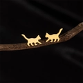 Orecchini a perno a forma di gatto dorato lucido esposti su un ramo scuro rustico - Oro