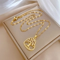 Detalle macro del collar de corazón árbol de la vida dorado en estuche beige - Estilo Árbol de la Vida de Corazón Dorado (H127)