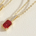 Macro-opname van de vergulde ketting met vierkante rode zirkoon hanger en witte details - Rood