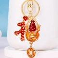 Detail showing Kirin keychain with red enamel Fu tag and orange rhinestone coins - Golden Toad Sending Fortune