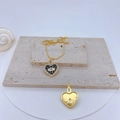 Detail of gold heart pendant with black enamel eye pattern and hammered texture - Black Enamel Heart Eye
