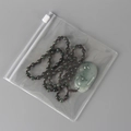 Transparent PVC storage bag holding a jade necklace pendant with green beads - 30 Micron 12x12cm Zipper / 100 Pcs/Pack