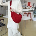 Detail of red crescent bag showing wrinkled texture and metal strap rings - Burgundy