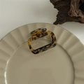 Close-up of tortoise shell square hair claw clip with Creation France logo on ceramic plate - Gold Label Small Hollow Square
