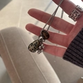Close-up of teardrop dalmatian jasper and tiger eye stone pendant necklace held by hand. - Spotted Stone (HN8618) / Silver