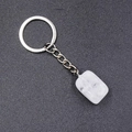Detail of a natural white crystal keychain with silver ring on a textured dark surface - White Crystal