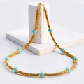 Gold titanium steel necklace featuring sky blue turquoise beads and polished round disks - Turquoise
