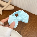 Mint blue ribbon bow hair claw clip in translucent finish held by hand on a wooden desk - Solid Blue - Bow