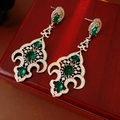 Détail de boucles d'oreilles vintage en argent avec pierres émeraude sur boîte en bois - Tige d'oreille en argent - Argent - Vert