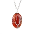 Macro detail of handmade wire wrapped tree of life pendant on red carnelian stone - Silver+Red Agate