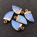 Close-up of five blue moonstone chili-shaped pendants with gold plating for jewelry DIY - Opal