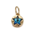 Detail of a round gold pendant with a blue star crystal and intricate edge engraving - Blue Star Disk