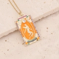 Macro view of The World tarot card pendant with golden frame and colorful gemstones - The World-Orange