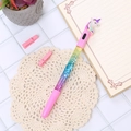 Penna glitterata con unicorno liquido con cappuccio rosa e criniera arcobaleno su sfondo bianco - Penna Unicorno LED Sabbie Mobili Viola