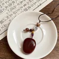Primo piano dettagliato di un ciondolo etnico vintage con perle di legno e motivo loto - Stile 21(21#)