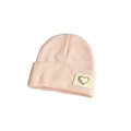 Detailed view of pink knitted beanie with heart label and high-quality stitch texture - One Size / Pink