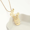 Collana con ciondolo a cactus dorato dal design traforato sul bordo di una ciotola bianca - Oro