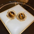 Detalle de pendientes vintage de encaje dorado con piedra ojo de tigre en caja blanca - Pasador de plata - Pendientes de botón de encaje de ojo de tigre color café marrón