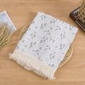 Detail of baby tassel blanket with grey leaf patterns and cream fringe on cotton gauze - Leaf