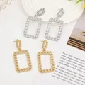 Detail of gold and silver chain-link rectangle earrings on a white embossed tray - Gold EH016 (Rectangular Chain)