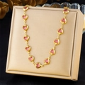 Dettaglio di una collana in acciaio inossidabile dorato con cristalli rosa a cuore - Stile Cuore Rosa (N3402)