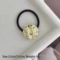 Detail of 3.5cm gold alloy hair tie with hammered texture on a velvet tray - Gold Embossed Round