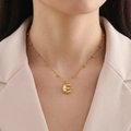 Detailed view of a gold-plated letter E pendant on a beaded satellite chain necklace - Letter E
