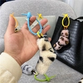 Close-up detail of cute leopard plush keychain with blue twisted tie creative bag charm - Black Beige Leopard Print