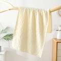 Soft cream yellow coral fleece towel with embossed bear and flower pattern on a wood branch - Off-white