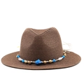 Detail of hand-woven brown straw sun hat with ethnic style beaded band decoration - Coffee