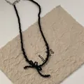 Handmade black beaded choker necklace with a black ribbon bow charm and silver clasp - Black Bowknot Necklace