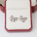 Boucles d'oreilles nœud rose avec strass et perle dans une boîte à bijoux rouge - Décor Nœud Rose