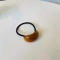 Elegante elastico per capelli con ovale in resina ambrata su superficie bianca - Marrone Ambra