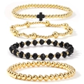 Detailed view of 4-piece gold and black beaded bracelets featuring a cross charm - Black Gold 4-Piece Set