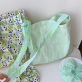 Detail of floral and textured tote bags with matching scrunchies on a white desk - Light Green Polka Dot Textured
