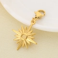 Macro shot of gold starburst charm with lobster clasp on a textured fabric background - Compass Star Style (KLJ6874-Z)