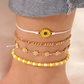Set of four anklets featuring yellow sunflower charms and golden chain layered on an ankle - Yellow - Anklet