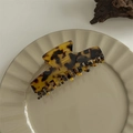 Detail view of large tortoiseshell pattern hair claw clip on a decorative ceramic plate - Flat Top Rib Claw