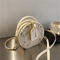 Beige round straw crossbody bag with floral embroidery and adjustable leather strap - White