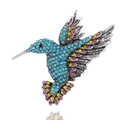 Detailed view of silver hummingbird brooch featuring colorful rhinestones and intricate feathers - Antique Silver + Lake Blue