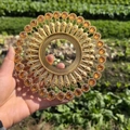 Close-up of golden metal circular wall decor with amber stones and radial pattern - Gold Orange Rhinestone