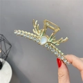 Detail einer goldenen Haarklammer im Rentier-Design mit tropfenförmigem Stein und Strass - Goldenes Hirschgeweih mit Strass