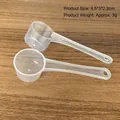 Transparent plastic measuring spoons in 5ml and 10ml sizes on a wooden surface - Transparent (9.5*3*2.2cm) / 5g (10ml) with Scale / Clear