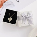 Dettaglio della collana con pendente a cuore in zircone in confezione regalo con nastro grigio - Scatola regalo / Bianco